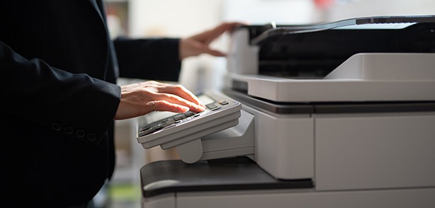 Woman typing into a printer